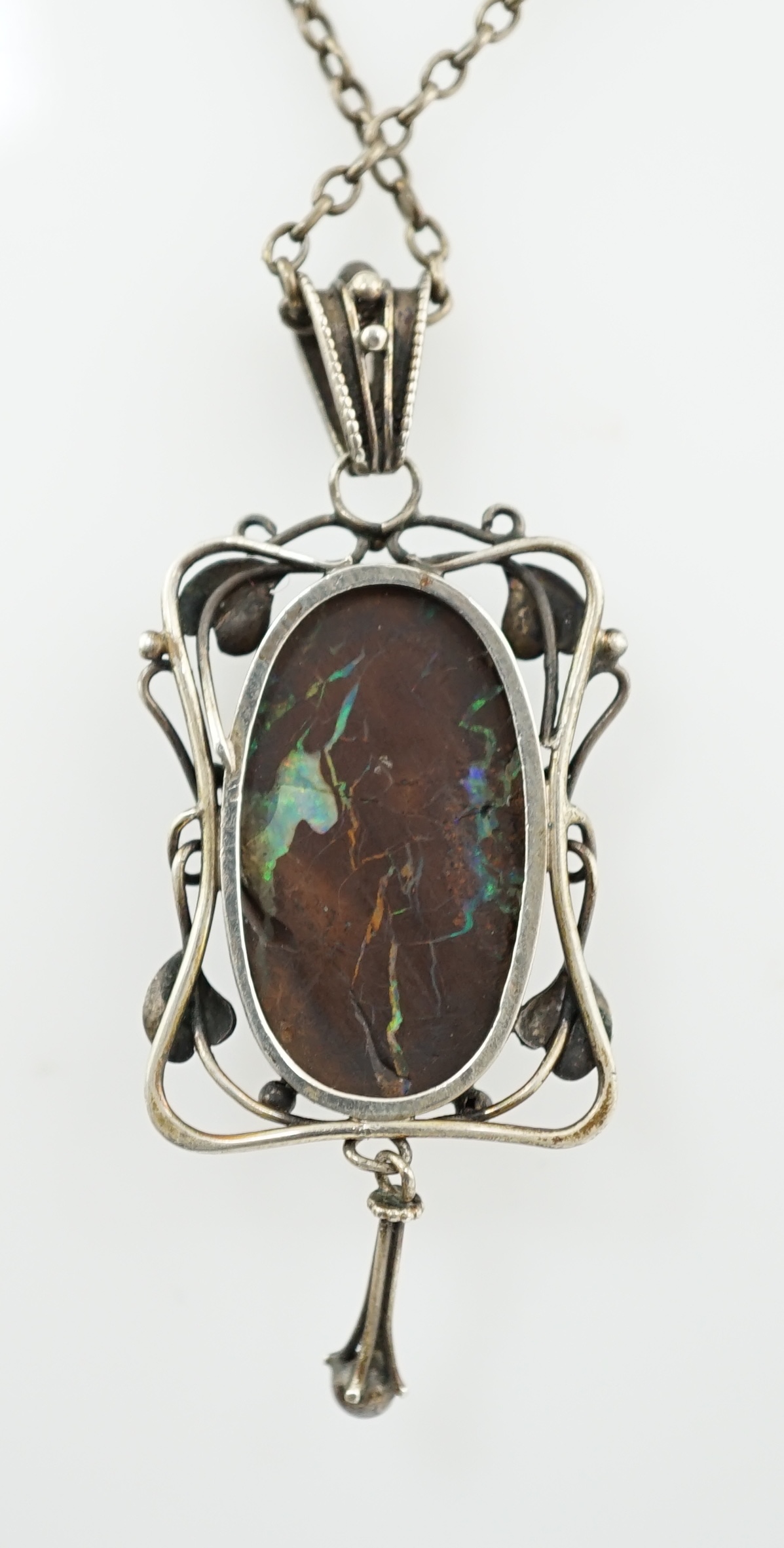 An Art Nouveau silver and oval black opal set drop pendant necklace